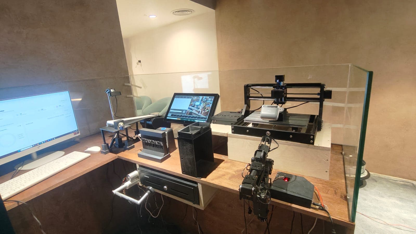 The Cinnamon360 retail test lab: a POS terminal with robotic arms, receipt printer, barcode display and cash drawer